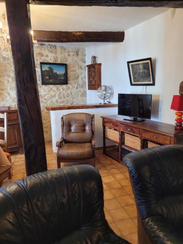 a living room with a desk and a leather chair at Logis du Grand Puits in Baudinard