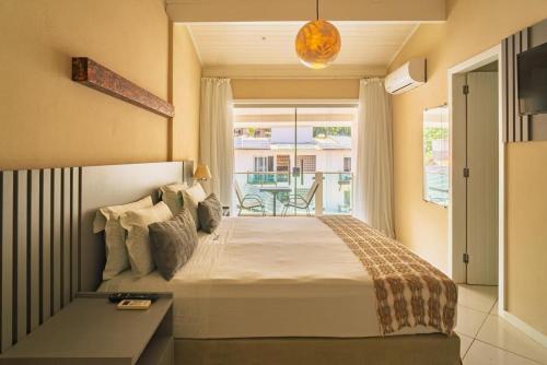 a bedroom with a large bed and a balcony at Pousada Mareia in Morro de São Paulo