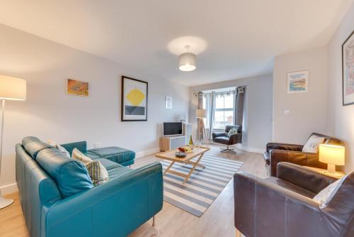 a living room with two blue couches and a table at 3 Bed in Felixstowe oc-fel in Felixstowe