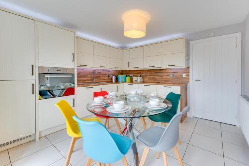 a kitchen with a glass table and chairs at 3 Bed in Felixstowe oc-fel in Felixstowe