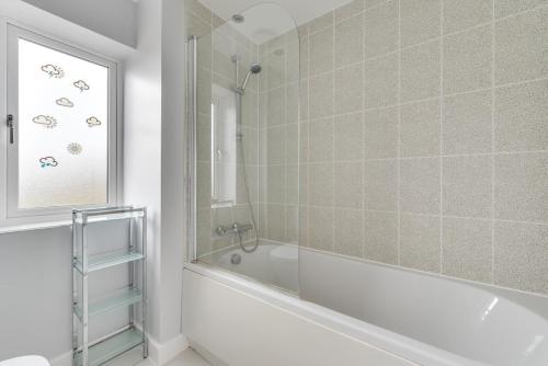a bathroom with a bath tub and a window at 3 Bed in Felixstowe oc-fel in Felixstowe