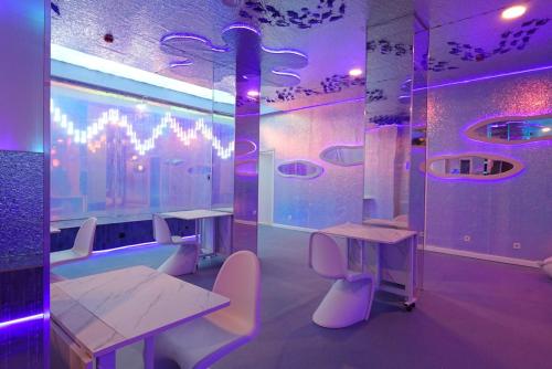 a room with tables and chairs and purple lights at The POD Suite Hostel Joaquin Sorolla in Valencia