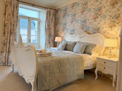 a bedroom with a large bed with floral wallpaper at Luxury Georgian Townhouse Tenby Sleeps 8 Parking Permit in Tenby