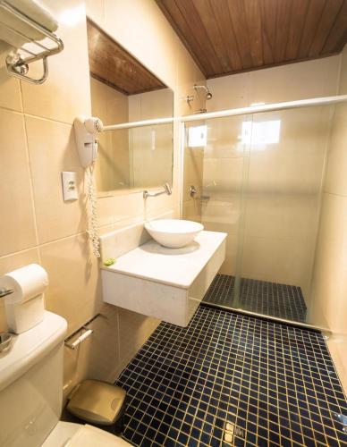 a bathroom with a sink and a glass shower at Pousada Mareia in Morro de São Paulo
