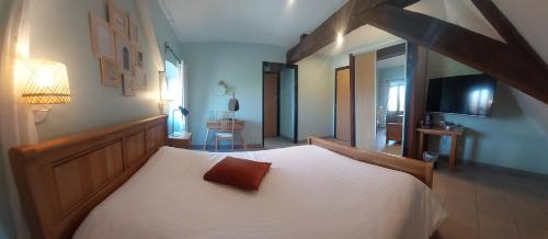 ein Schlafzimmer mit einem weißen Bett und einem Kissen darauf in der Unterkunft La Forge De Labbaye in Liessies