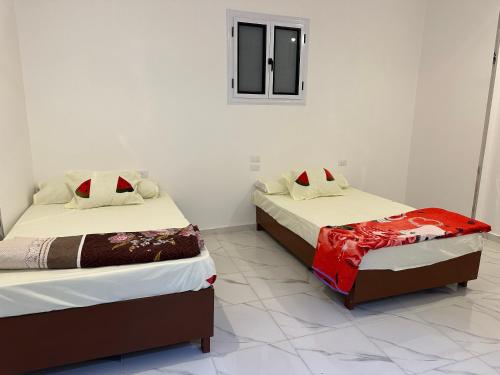 two beds sitting next to each other in a room at golden house in Al Aqālitah