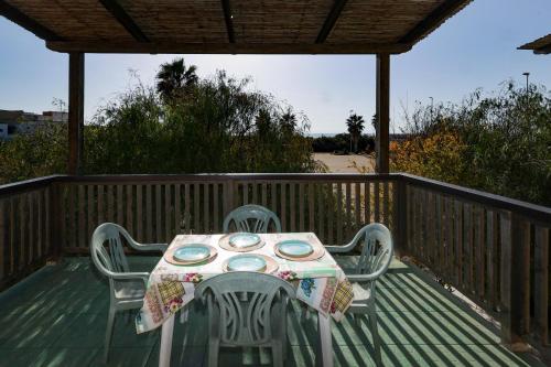 a table and two chairs on a deck with a table and chairs at Ocra Fronte Mare in Torre Mozza