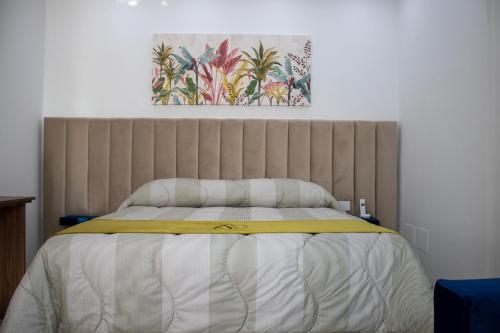 a bedroom with a bed with a painting on the wall at Augustea Travel Rooms in Frignano