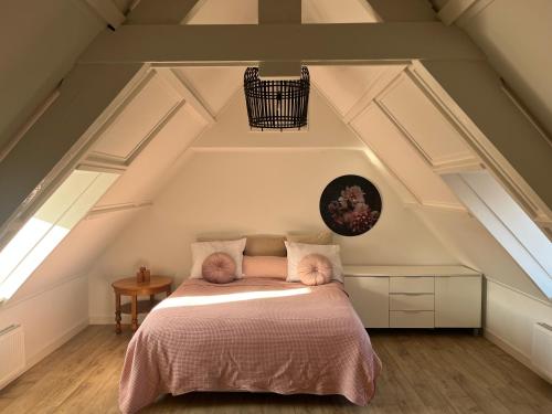 a bedroom with a bed in the attic at B&B De Holevoet in Scherpenzeel