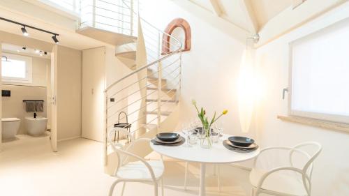 a white dining room with a white table and chairs at DOMUS 1435 - Iconic Suites in Centro in Mantova