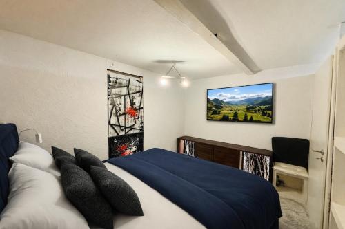 a bedroom with a blue and white bed and a tv at Schones Apartment mit Charme und privatem Garten in Schwieberdingen
