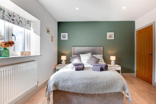 a bedroom with green walls and a bed with purple pillows at 3 Bed in Hindolveston oc-1986 in Hindolveston
