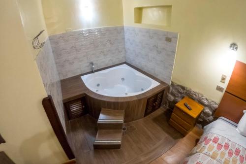 a bath tub in a room with a bed at Cusco'sHome 3 in Cusco