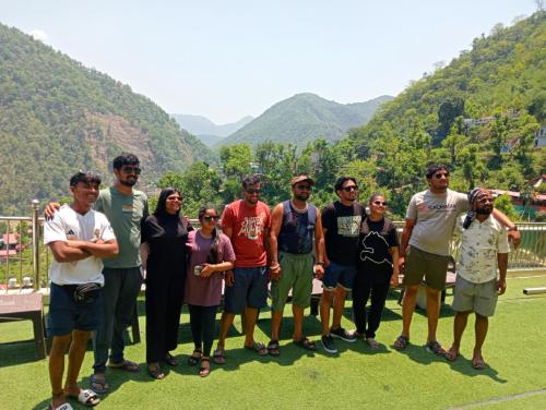 a group of people posing for a picture with mountains in the background at Mountain View Cottage Shivpuri Rishikesh in Rishīkesh