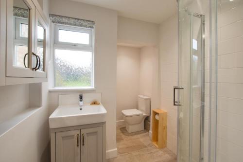 a bathroom with a sink and a toilet and a window at 2 Bed in Dersingham oc-2154 in Dersingham