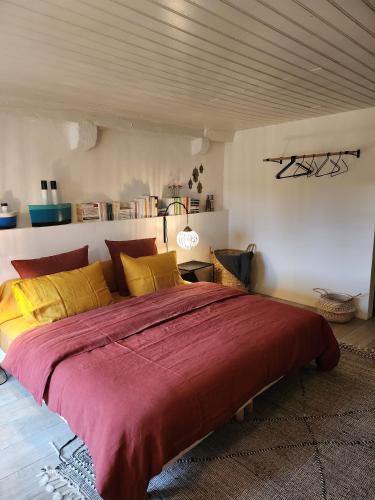 a bedroom with a large bed with a red blanket at Au Bourg in Le Landeron
