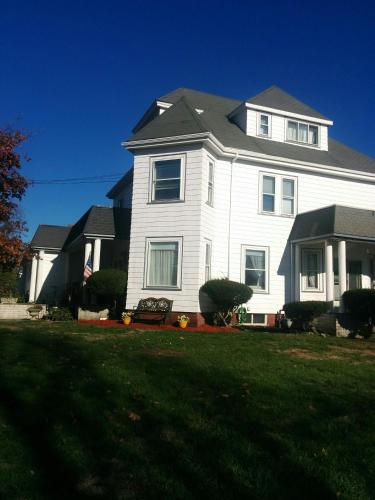 a large white house with a lawn in front of it at Château sur Mer Bed & Breakfast in Winthrop