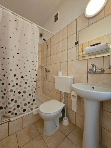 a bathroom with a toilet and a sink and a shower at Hotel Eden 24h in Rzeszów