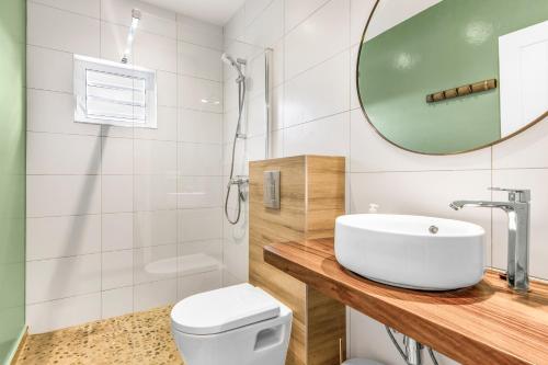 a bathroom with a sink and a toilet and a mirror at Kakina Lodges Jan Thiel in Jan Thiel