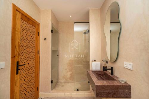a bathroom with a shower and a wooden door at Chambre avec vue panoramique in Noûnouech