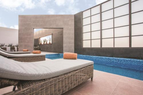 a room with two beds and a swimming pool at La Quinta by Wyndham Aguascalientes in Aguascalientes