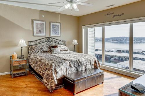 a bedroom with a bed and a large window at Lake View + Pool Access: Waterfront Ozark Escape! in Four Seasons
