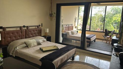a bedroom with a bed and a large window at Bokoba Condo Tulum Maia in Tulum