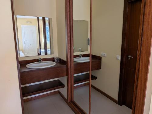 a bathroom with two sinks and a large mirror at Sun Galicia Hotel y Apartamentos in Sanxenxo