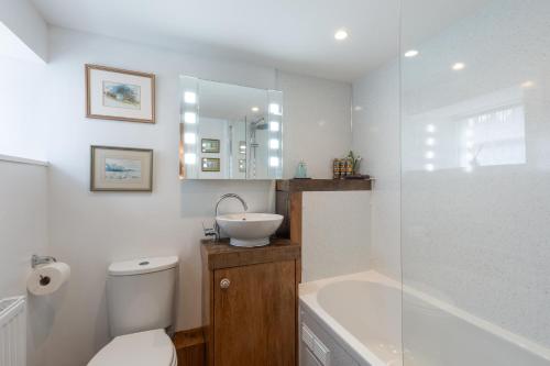 a bathroom with a toilet and a sink and a tub at Stone Barn in Minehead