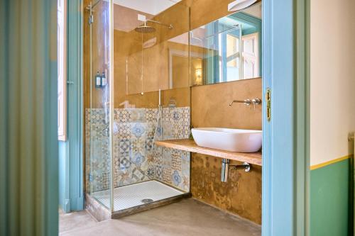 a bathroom with a sink and a glass shower at Palazzo Mercanzia in Lecce