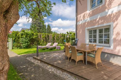 a patio with a table and chairs next to a building at Das Grüne Hotel zur Post - 100 % BIO in Salzburg