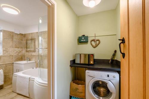 a bathroom with a washing machine and a tub at 2 Bed in Chatton oc-r27205 in Chatton