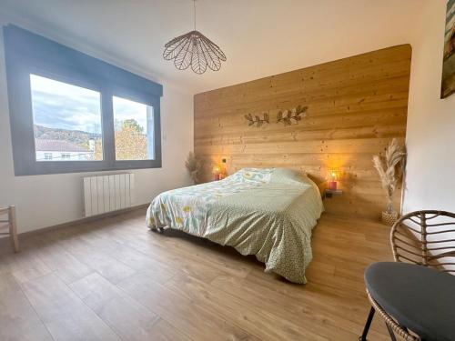 a bedroom with a bed and a large window at Le Gite des Fleurs in Ramonchamp