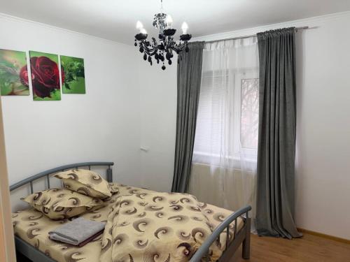 a bedroom with a bed and a chandelier at Afrodita Apartment in Timişoara