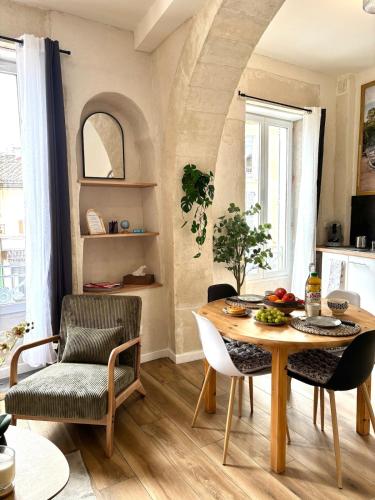 a dining room with a table and chairs at CLIM - Hypercentre - Arche en pierre in Nîmes