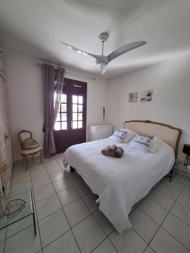 a bedroom with a large bed with two dolls on it at Chrysalide in Baillif