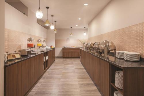 a restaurant with a long counter with plates on it at La Quinta by Wyndham Aguascalientes in Aguascalientes