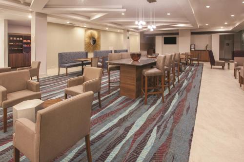 a waiting room with chairs and tables and a podium at La Quinta by Wyndham Aguascalientes in Aguascalientes