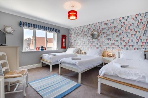 a room with three beds and a window at 5 Bed in Seahouses oc-nb621 in Seahouses
