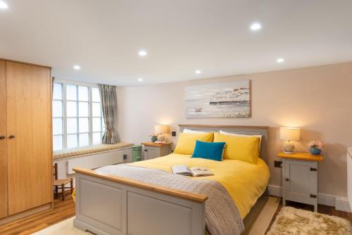 a bedroom with a bed with yellow and blue pillows at Stone Barn in Minehead