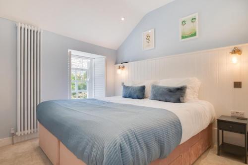 a bedroom with a large bed with two blue pillows at 2 Bed in Newlyn oc-oldbak in Newlyn