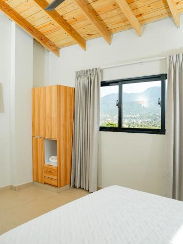 a bedroom with a white bed and a window at Ocean Winds Hotel in San Felipe de Puerto Plata
