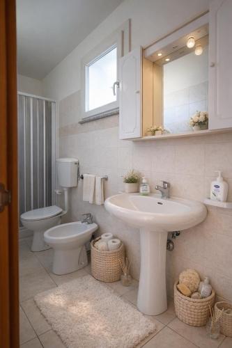 a bathroom with a sink and a toilet and a mirror at Attico Fronte Mare in Torre Mozza