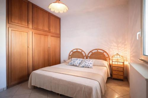 a bedroom with a bed with a wooden headboard at Attico Fronte Mare in Torre Mozza