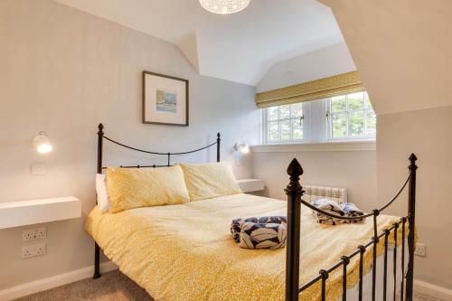 a bedroom with a black bed with a yellow bedspread at 2 Bed in Beadnell oc-gd1889 in Beadnell