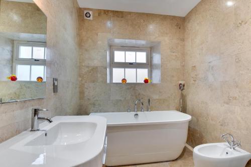 a white bathroom with a tub and a sink at 2 Bed in Beadnell oc-gd1869 in Beadnell