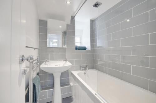 a white bathroom with a sink and a bath tub at 2 Bed in West Looe oc-l30054 in Looe
