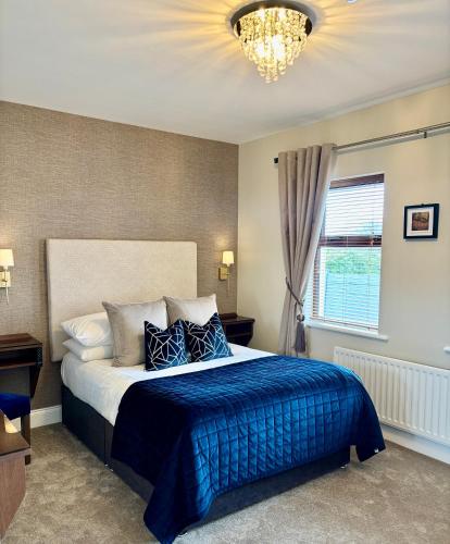 ein Schlafzimmer mit einem großen Bett und einer blauen Decke in der Unterkunft Killaran House in Killarney