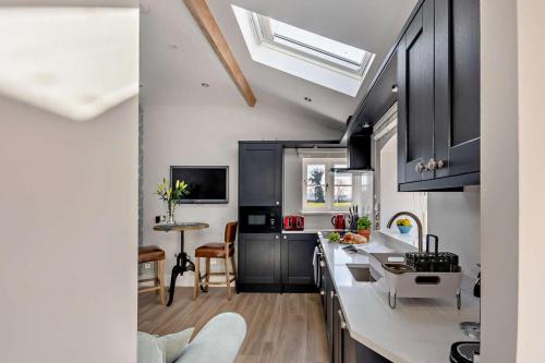 a kitchen with black cabinets and a white counter top at 1 Bed in Cilcain oc-s29009 in Cilcain