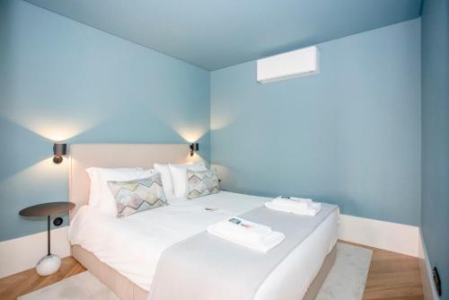 a white bed in a room with blue walls at Liiiving in Porto - Ribeira Design Apartment in Porto